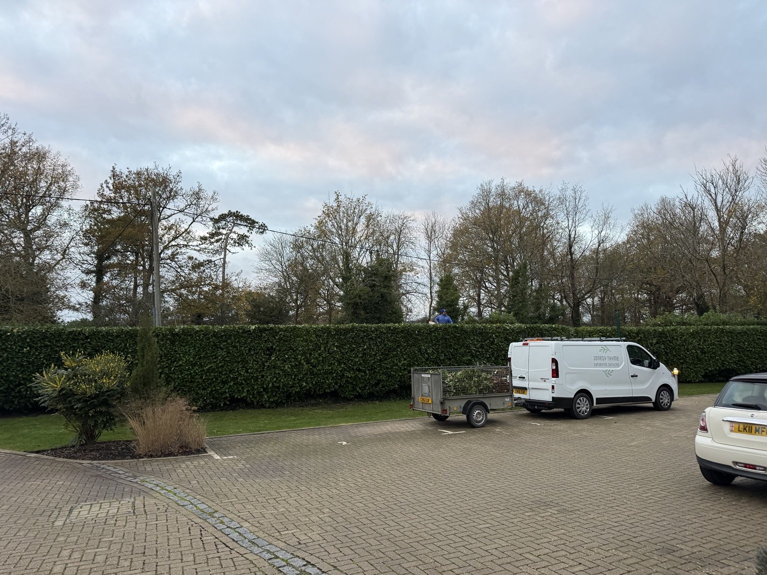 Jonesy Thyme van and team carrying out hedge maintenance at managed residential grounds in Beare Green, Surrey